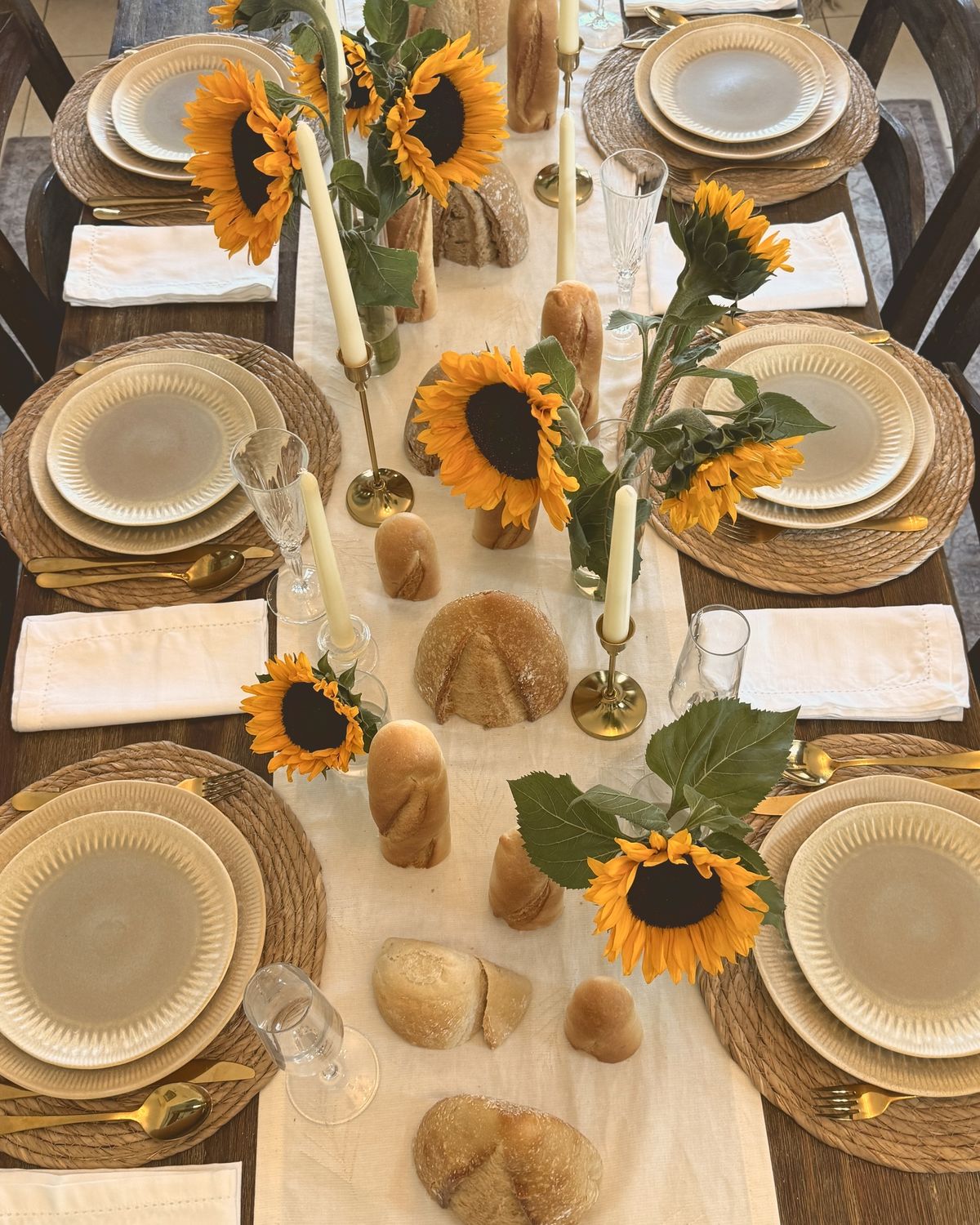 A long table with sunflowers, fresh bread and candles down the centre