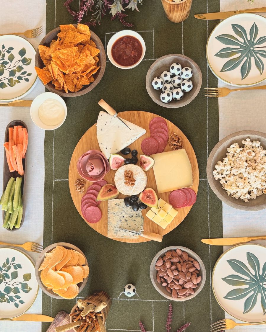 A game-day grazing table with a football pitch runner, a cheese board and snacks
